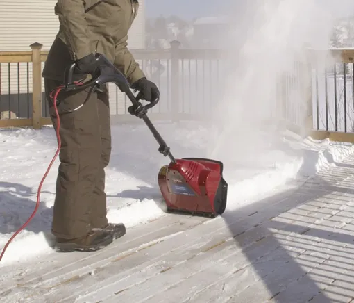 женщина убирает двор электролопатой