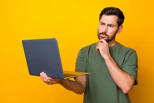 Мужчина думает во время работы на ноутбуке Мужчина думает во время работы на ноутбуке