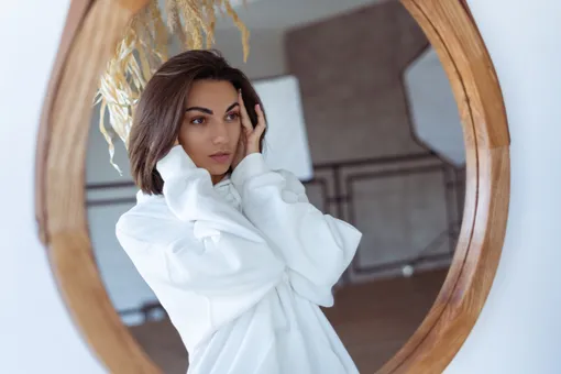 Девушка смотрит в зеркало