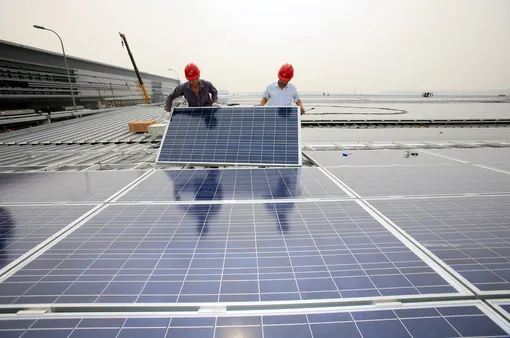 two workers mouns a solar panel