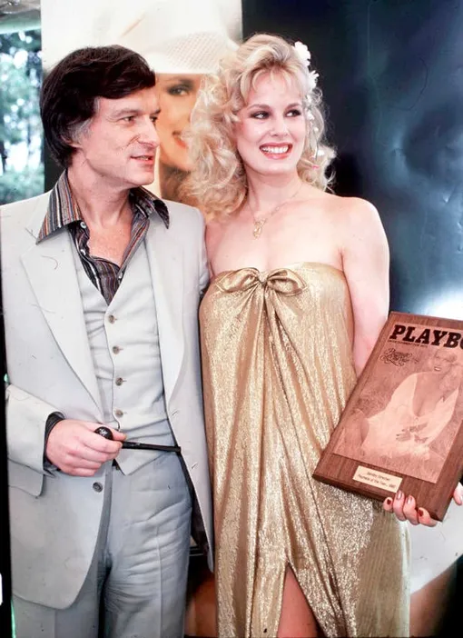 Дороти Страттен и Хью Хефнер держат в руках табличку обложки Playboy с фотографией девушки Дороти Страттен и Хью Хефнер держат в руках табличку с обложкой Playboy с фотографией девушки