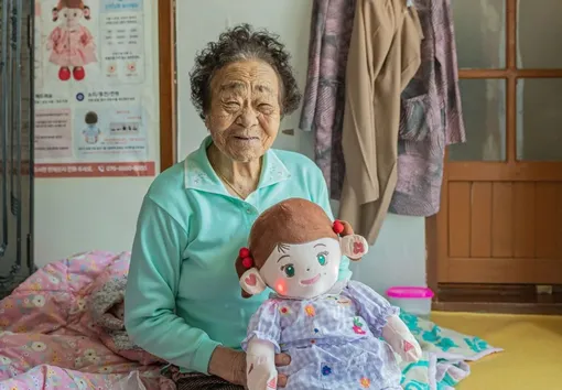 Пожилая женщина из Южной Кореи с ИИ-куклой Hyodol / Пожилая женщина из Южной Кореи с ИИ-куклой Hyodol /
