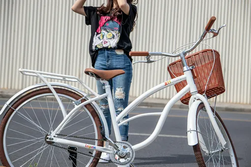 woman standing behind a white elegant bicycle