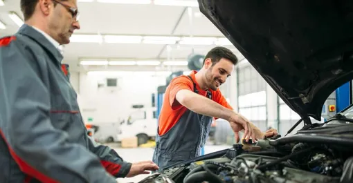 два сервисмена перед открытым капотом