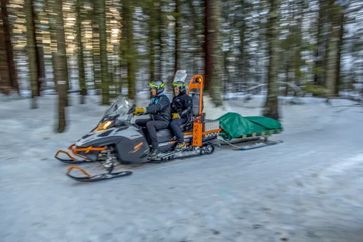 двое на снегоходе с санями