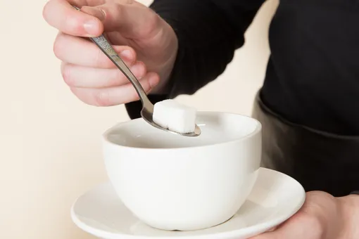 мужчина добавляет сахар в чай