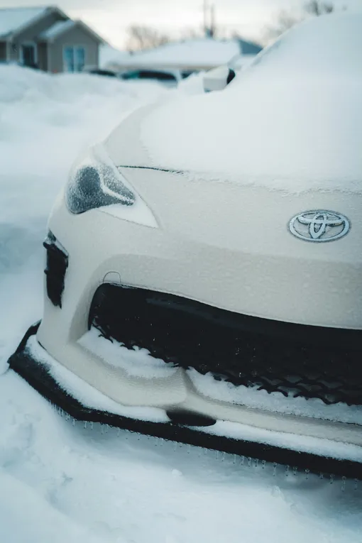 занесенный снегом белый автомобиль