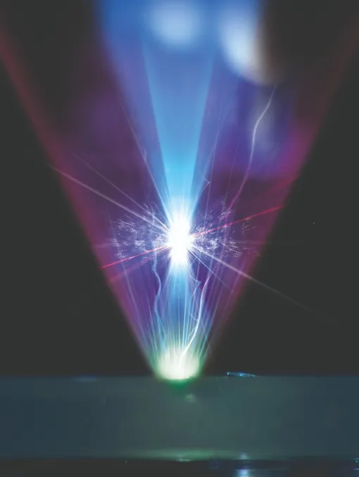 Иллюстрация по фотографии. Генерация когерентного гармонического фокуса (CHF). Луч лазера фокусируется на мишени, а отраженный пурпурный луч образует CHF чрезвычайно высокой интенсивности.