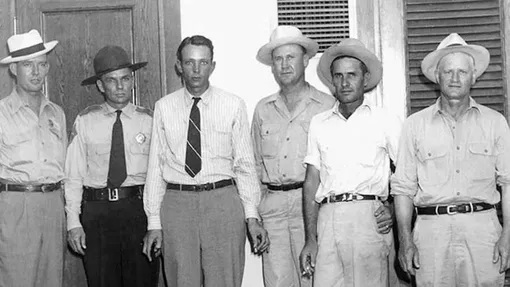 Подозреваемый Суинни (третий слева) со следователями. Подозреваемый Суинни (третий слева) со следователями.