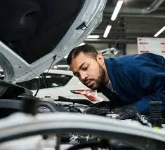 механик рассматривает двигатель машины