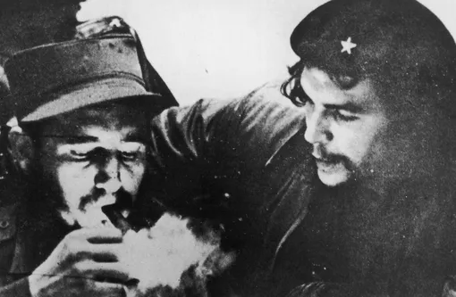 Кубинский революционер Фидель Кастро (слева) закуривает сигару, в то время как аргентинский революционер Че Гевара (1928-1967) наблюдает за ним Кубинский революционер Фидель Кастро (слева) закуривает сигару, в то время как аргентинский революционер Че Гевара (1928-1967) наблюдает за ним